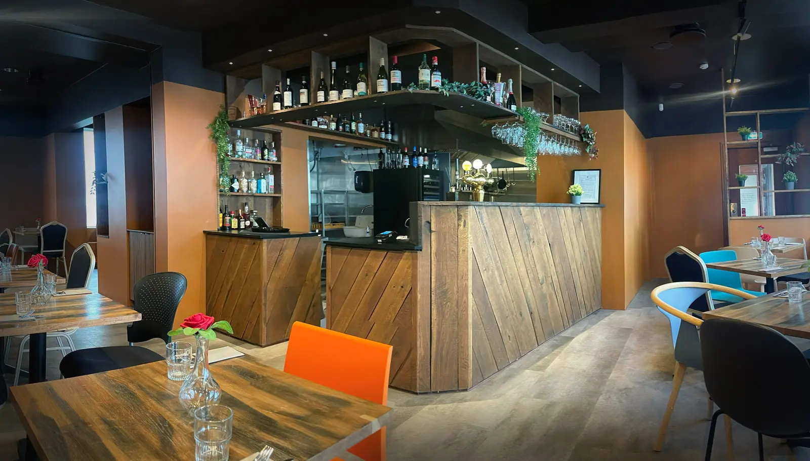 The dining room at Fish House, looking across the timber tables towards the bar