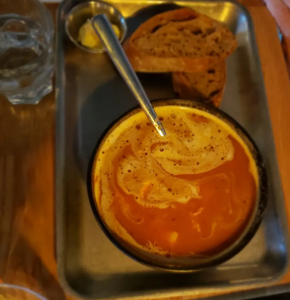 Soup served on a steel tray with bread