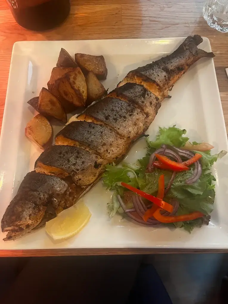 A whole grilled fish with roasted potatoes