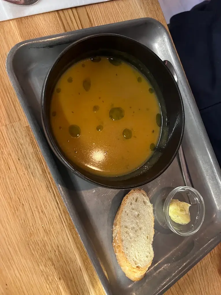 Soup served on a steel tray with bread